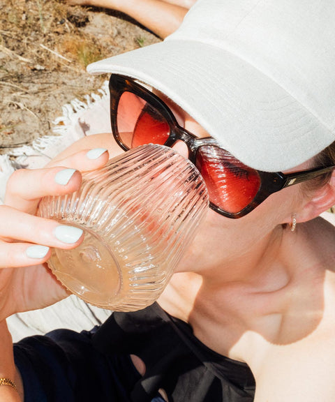 Girl on the beach drinking from the Djuce Studio Unbreakable Wine Glass